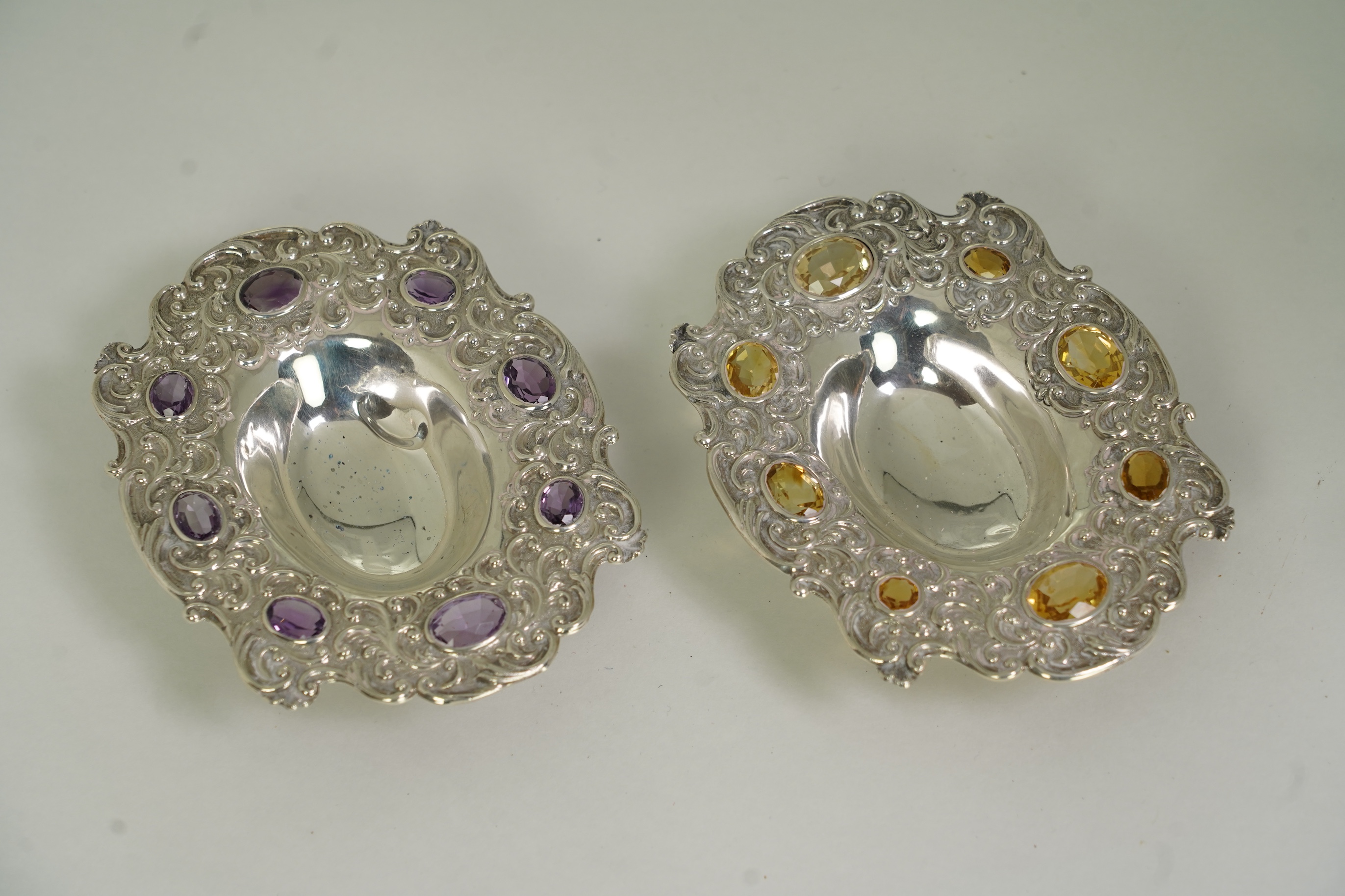 Two unusual late Victorian repousse silver dishes, by Daniel & John Welby, one border inset with eight oval cut amethysts, the other with eight oval cut citrines
